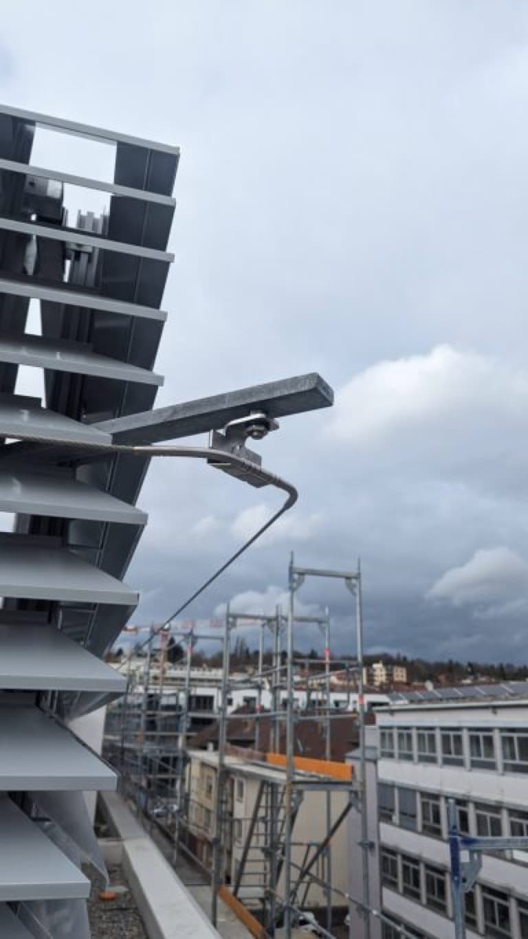 Solaranlage auf einem Gebäude mit grauem Himmel im Hintergrund.